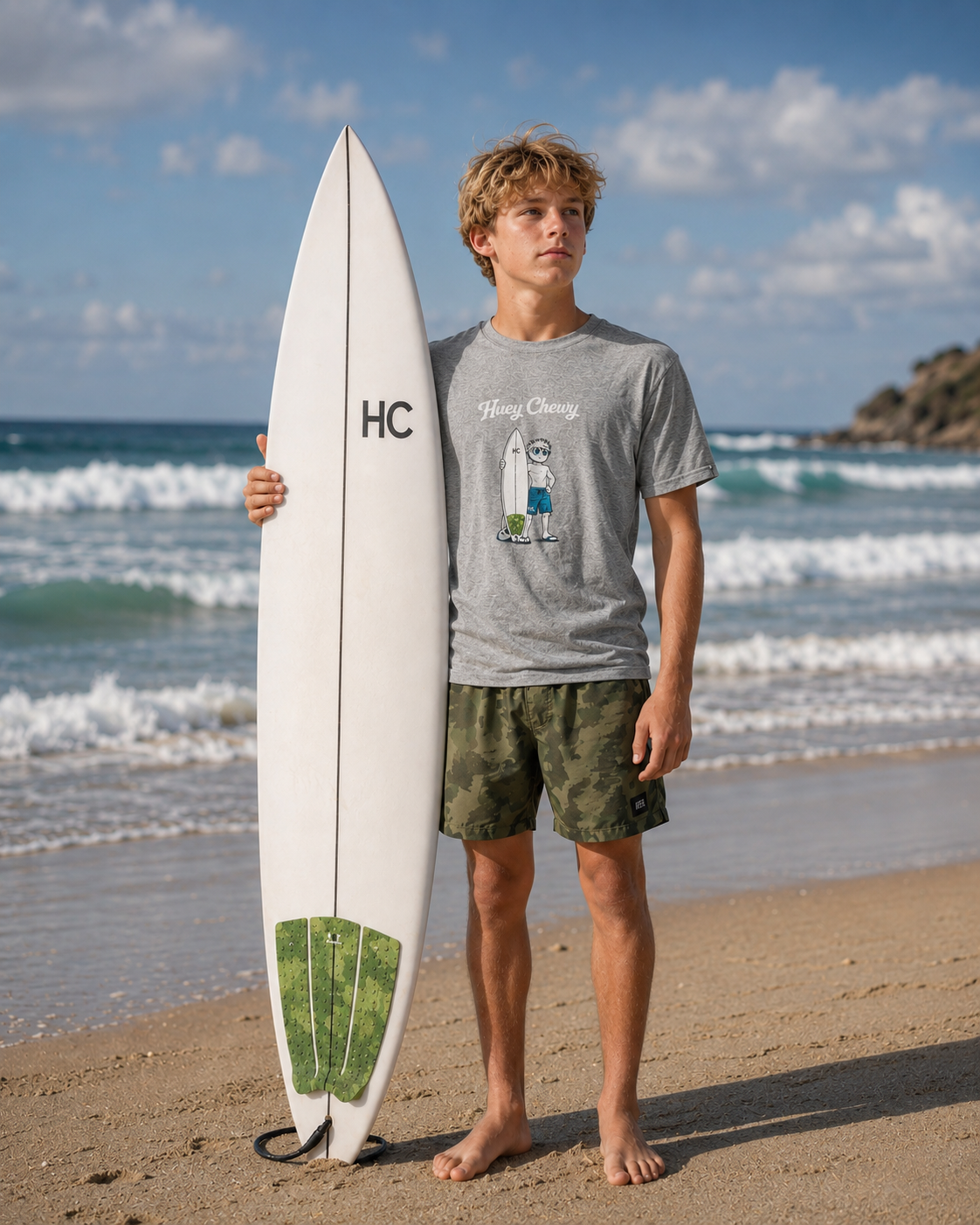 Boy at the beach with his surfboard wearing Huey Chewy light grey surfer t-shirt