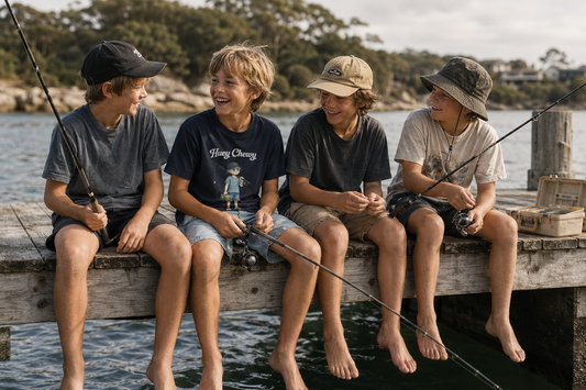 Boy fishing with friends on the dock wearing Huey Chewy blue fisherman t-shirt